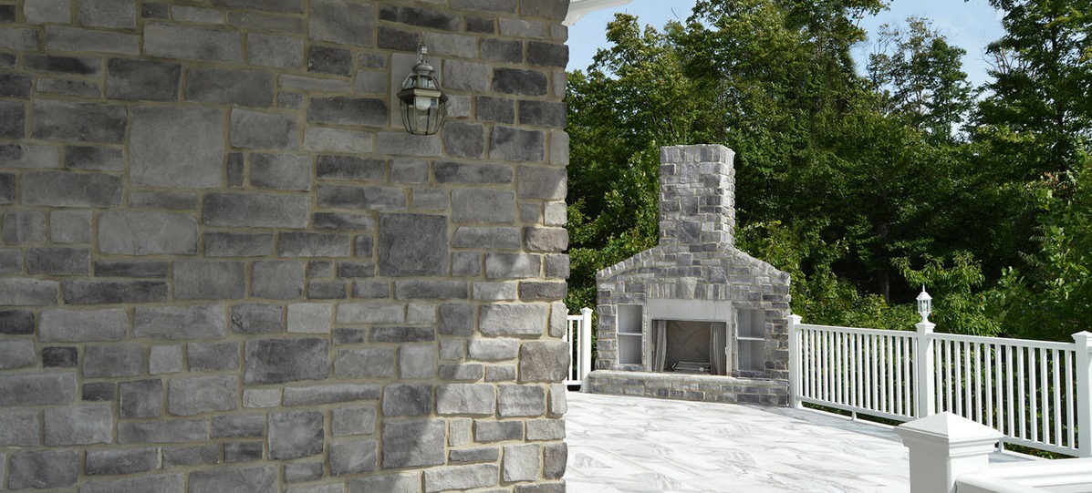 What are the advantages of using stone for a fireplace wall compared to other materials?